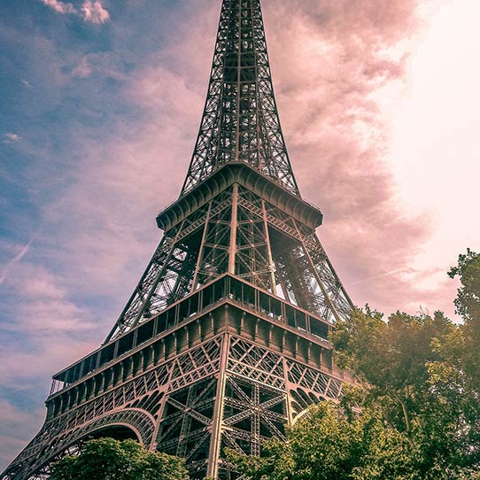 Eiffel Tower at sunset with a glowing sky.