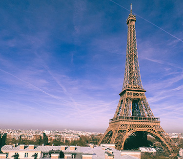 Eiffel Tower standing tall with clouds swirling overhead